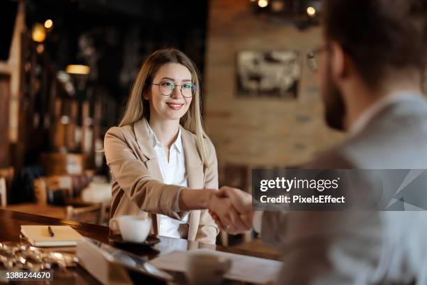 female and male business partners shake hands - cafe staff stock pictures, royalty-free photos & images