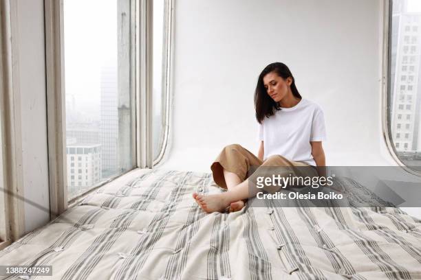 young woman in loft studio with mattress and white background - mola objeto manufaturado - fotografias e filmes do acervo