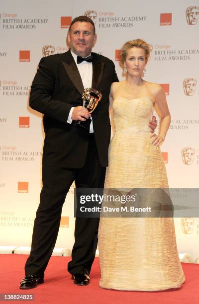 Graham King accepting the Best Animated Film award on behalf of Gore Verbinski for Rango poses with presenter Gillian Anderson in the press room at...