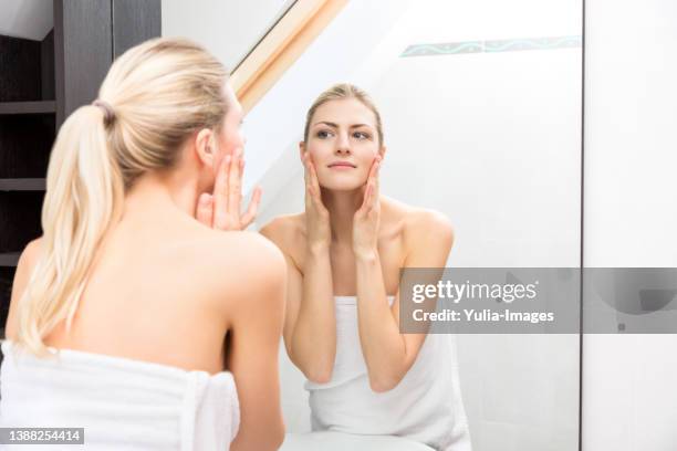 woman from shower looking herself at the mirror - blackheads photos et images de collection