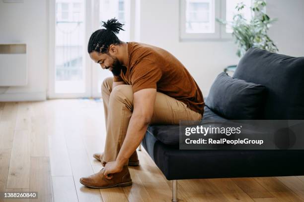 business man dressing up with classic, elegant shoes - black male feet stockfoto's en -beelden