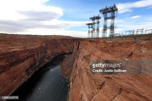 Electrical transmission towers stand over the Colorado River near the Glen Canyon Dam at Lake Powell on March 28, 2022 in Page, Arizona. As severe...