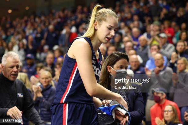 Dorka Juhasz of the UConn Huskies is helped off the court by the trainer after suffering a wrist injury during the first half against the NC State...