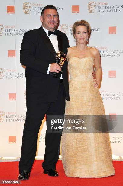 Producer Graham King and actress Gillian Anderson pose in the press room with the Animated Film award for 'Rango' during the Orange British Academy...