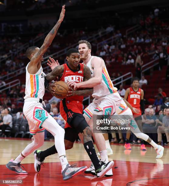 Kevin Porter Jr. #3 of the Houston Rockets drives to the basket between Jakob Poeltl of the San Antonio Spurs and Dejounte Murray during the first...