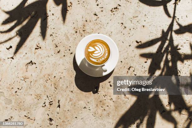 top view of white cappuccino cup on stone table. cafe culture and lifestyle. - latte art stock pictures, royalty-free photos & images