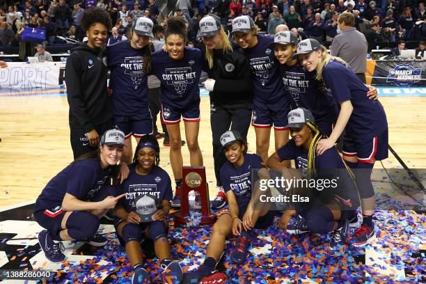 Members of the UConn Huskies pose for photos with the regional championship trophy after defeating the NC State Wolfpack 91-87 in 2 OT in the NCAA...