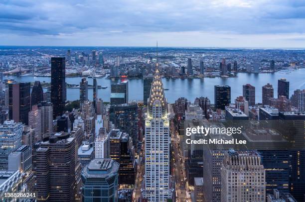 high angle twilight view of chrysler building, east river and queens in new york - queens stad new york stock-fotos und bilder