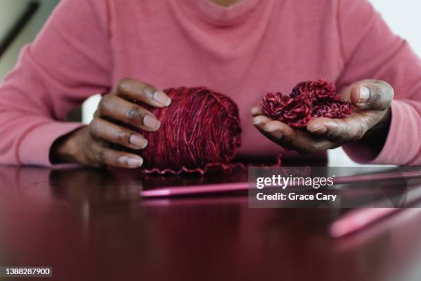 woman holds tangled yarn after unraveling/frogging knitting project - stricknadel stock-fotos und bilder