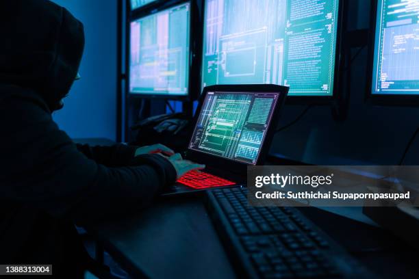 asian female hacker wearing black mask in the server room for internet attack. - computer hacker stockfoto's en -beelden