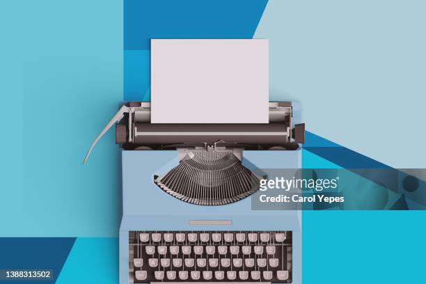 top  view of a typewriter from the 70s with blank paper for text, isolated on bluebackground. - reporting stock-fotos und bilder