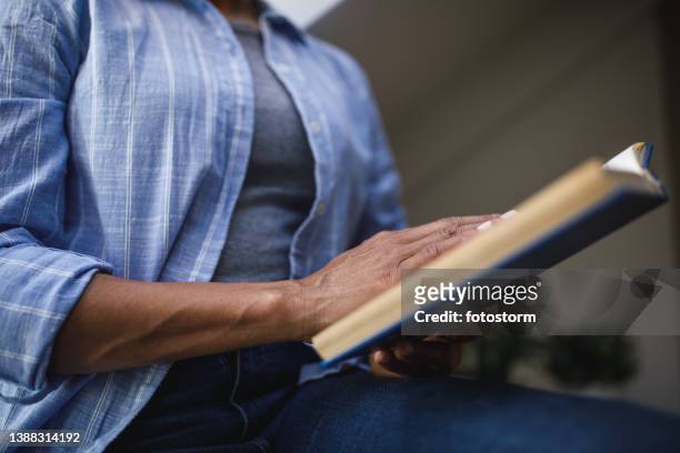 selective focus shot of unrecognizable woman reading a book - hand turning page stock pictures, royalty-free photos & images