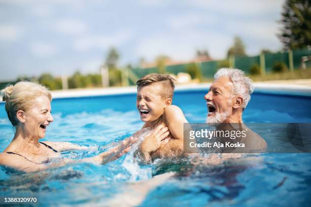 grandparents enjoying with their grandson at the pool. - lido stock pictures, royalty-free photos & images