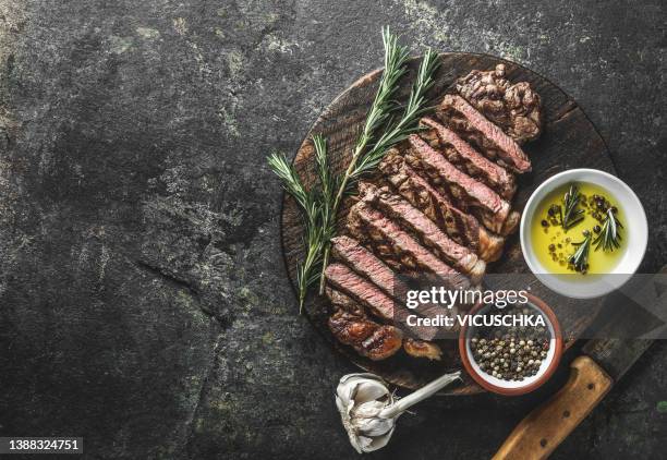 roasted sliced meat barbecue beef steak, striploin, with oil, herbs and spices. - steak stock-fotos und bilder