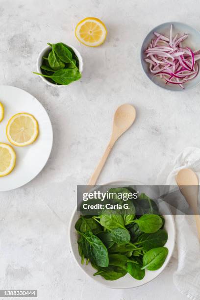 spinach preparation with red onion and lemons. healthy food recipes - cutting red onion stock pictures, royalty-free photos & images