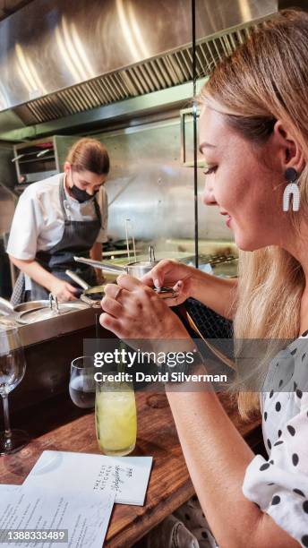 South African wine professional Delaille Raubenheimer photographs the menu while seated at the bar at chef Luke Dale Roberts' The Test Kitchen...