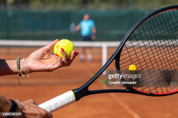 hands holding racket and tennis ball - tennis raquet stock pictures, royalty-free photos & images