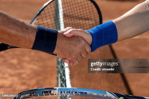 estrechar la mano en la cancha de arcilla - tennis net fotografías e imágenes de stock