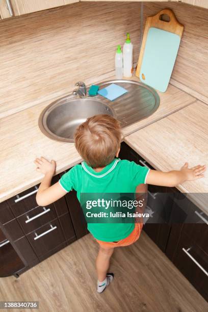 unrecognizable boy climbing on counter - daylight saving time 2021 stock pictures, royalty-free photos & images