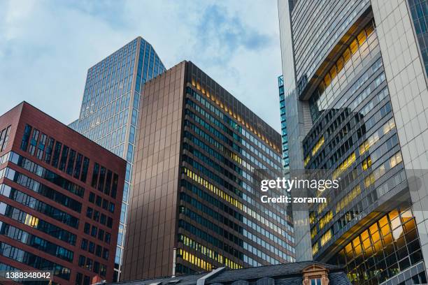 flachwinkelansicht auf firmengebäude in der frankfurter innenstadt - finanzviertel stock-fotos und bilder