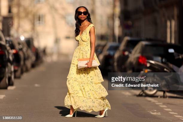 Emilie Joseph @in_fashionwetrust wears black sunglasses, a pale yellow with green and yellow flower print pattern V-neck / tank-top / backless /...