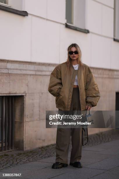 Alessa Winter is seen wearing a beige khaki jacket and grey wide pants from The Frankie Shop, white Zara top, Nubikk black leather boots, Balenciaga...