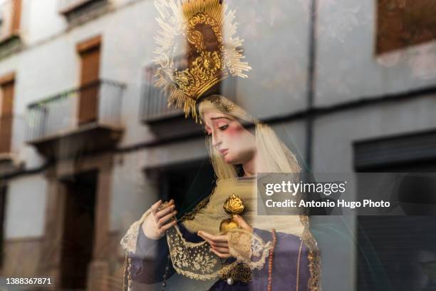 statue of a virgin exposed in a street. view through a glass. spanish holy week. - virgin mary stock pictures, royalty-free photos & images