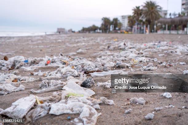 beach full of garbage, wet wipes and waste that people throw in the toilet. concept of ocean pollution and environmental destruction, málaga, spain. - world toilet day foto e immagini stock