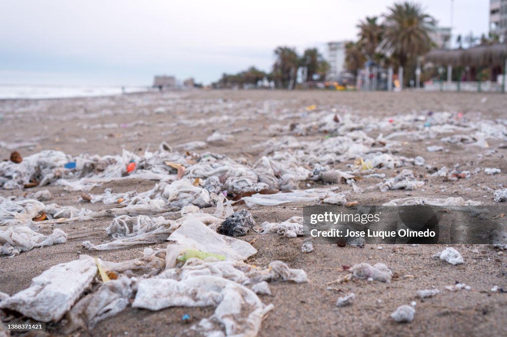 Beach full of garbage, wet wipes and waste that people throw in the toilet. Concept of ocean pollution and environmental destruction, Málaga, Spain.