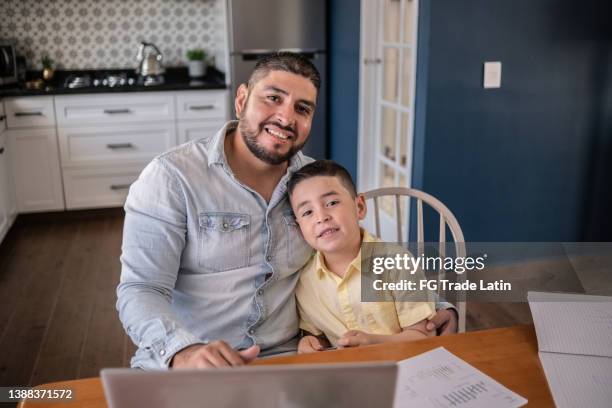 portrait of latin boy studying and father working at home - single father stock pictures, royalty-free photos & images