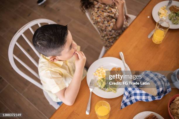 cute boy eating breakfast at home - reunion familia stock pictures, royalty-free photos & images