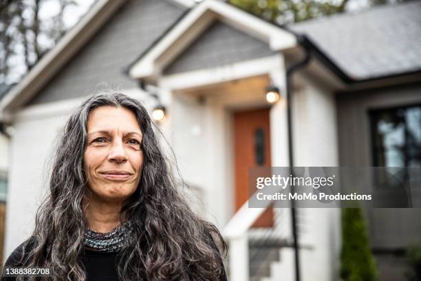 portrait of senior woman in front of home - senior man grey long hair stock-fotos und bilder