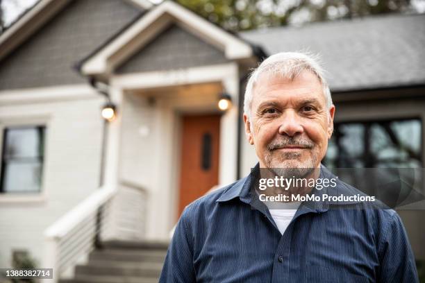 portrait of senior man in front of home - ziegenbart stock-fotos und bilder