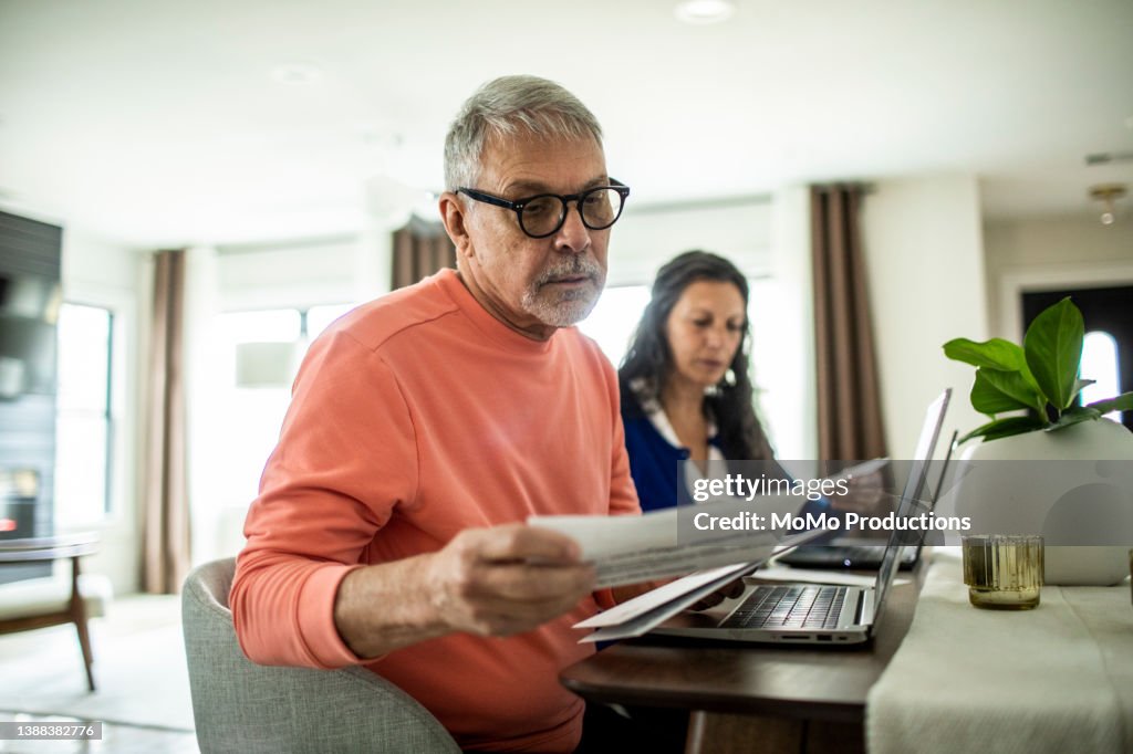 Senior couple payings bills inside home