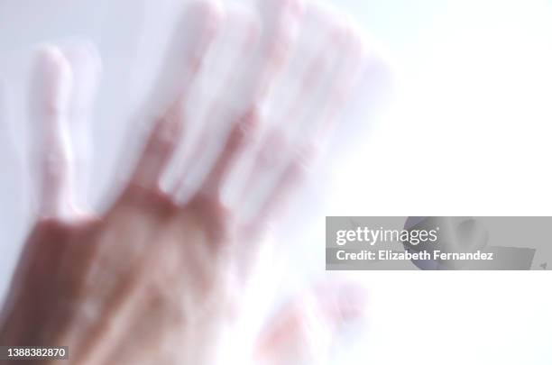 blurred motion of female hand on white background. mental illness concept, copy space on image. - schütteln stock-fotos und bilder