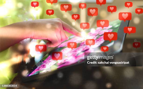 young woman doing likes on social media using digital tablet - new media imagens e fotografias de stock