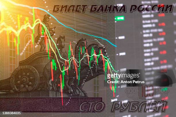 banknote of russian rubles on the background of stock charts. concept of economic sanctions in russia - geldstrafe stock-fotos und bilder
