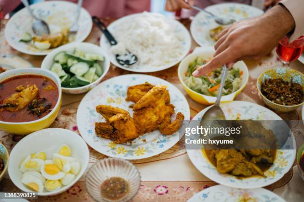 マレーシアのマレー系家族がハリ・ラヤを祝い、自宅で家族再会の夕食をとる - イフタール ストックフォトと画像