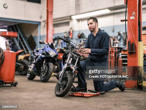 mexican male mechanic in his shop - motorcycle mechanic stock pictures, royalty-free photos & images