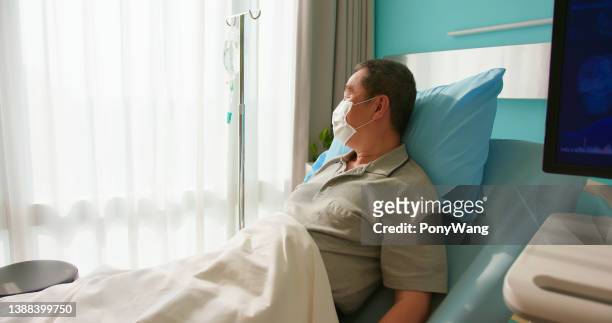 senior man lying on bed - chemotherapy man stock pictures, royalty-free photos & images