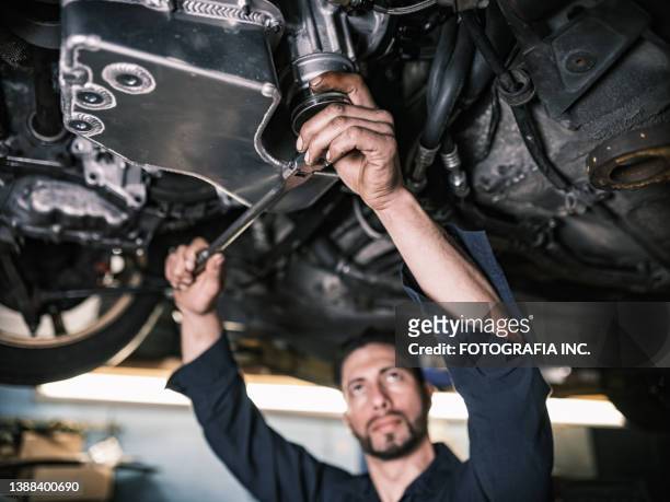 mexican male mechanic in his shop - oil change stock pictures, royalty-free photos & images