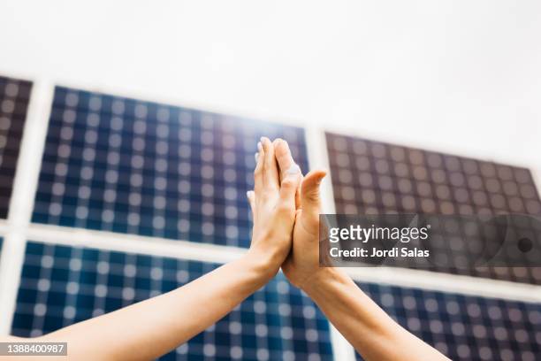 handshake with solar pannel as background - climate agreement stock pictures, royalty-free photos & images
