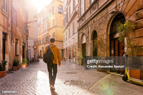 young man exploring rome, rear view, lazio, italy - european street stockfoto's en -beelden