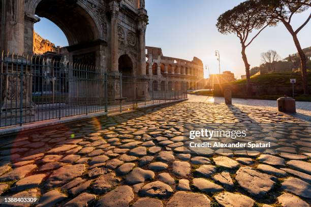 coliseum and arch of constantine at sunrise, rome, italy - arch of constantine stock-fotos und bilder