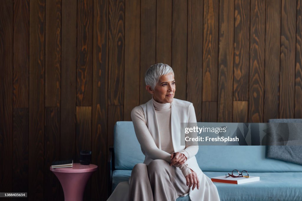 Portrait of a Beautiful Happy Senior Woman Sitting on a Couch in her Office