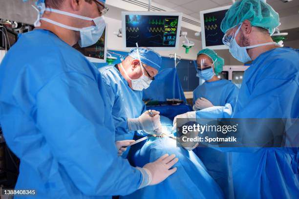 surgical team wearing scrubs performing operation on patient - performing arts event stockfoto's en -beelden