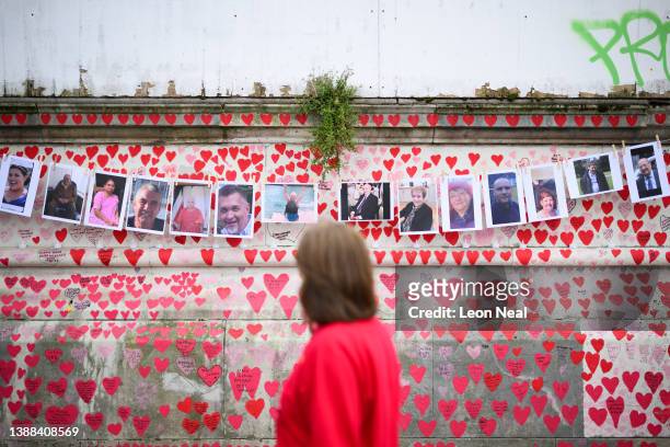 Members of the public view the photos of some of those who died during the Covid-19 pandemic, on the first anniversary of the creation of the Covid...