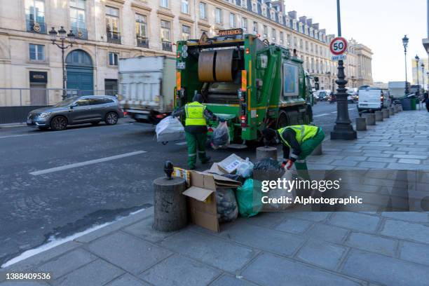 garbage truck on a street in paris - vuilnisman stockfoto's en -beelden