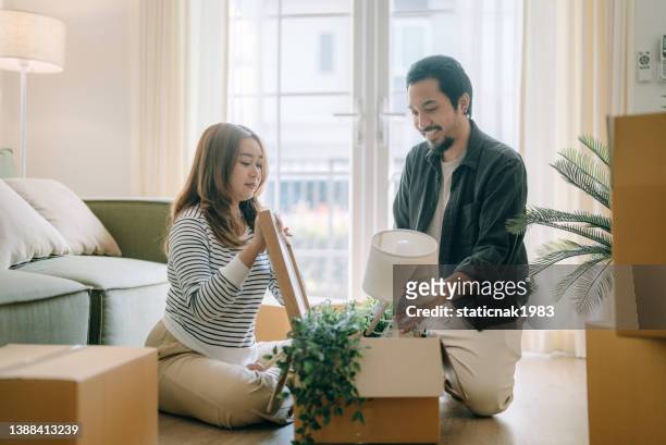 coppia felice che trasferisce una nuova casa. - apartment living asian foto e immagini stock