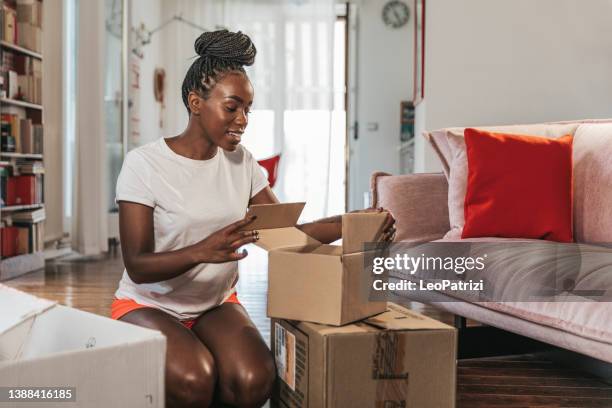 mujer que abre un paquete de un pedido de tienda en línea - enviar actividad fotografías e imágenes de stock